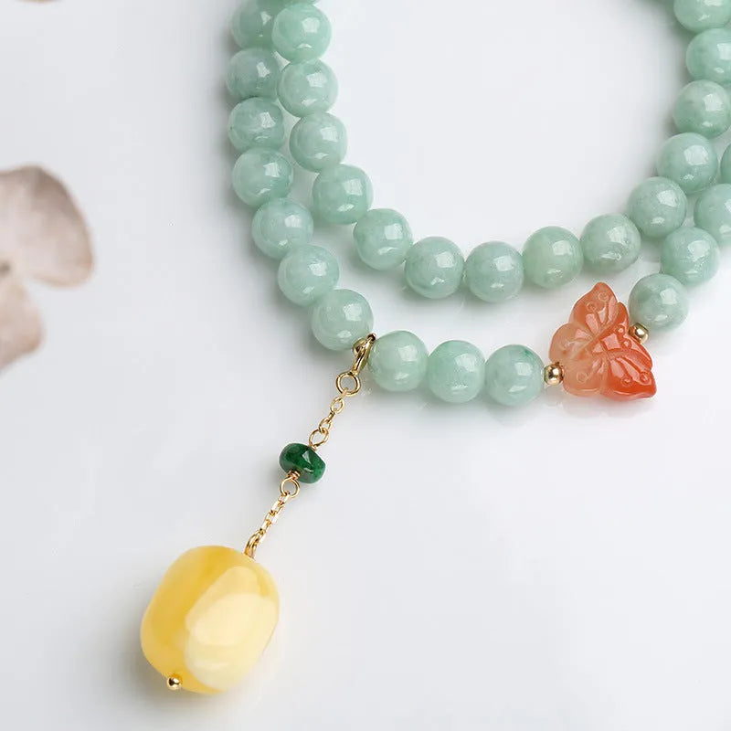 Close-up of a double-layer women's bracelet with green jade round beads and honey-coloured beeswax barrel beads.