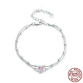Close-up of a sweet girlish style sterling silver bracelet with a small heart pendant on an adjustable chain.