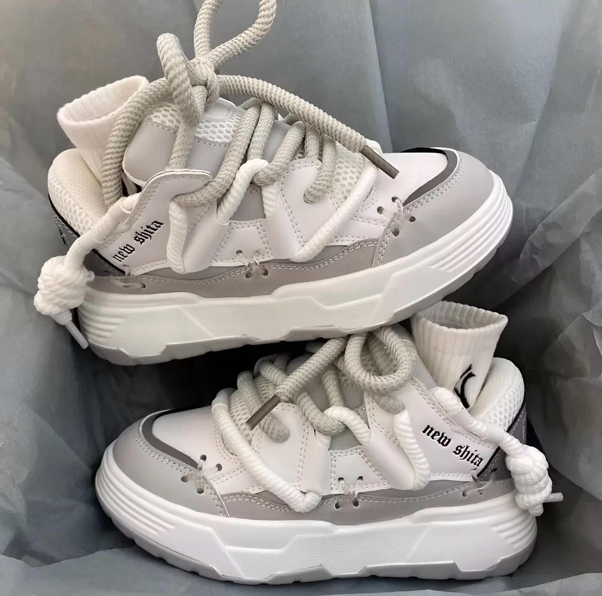 Women's grey clunky platform sneakers with a thick rubber sole and lace-up front, shown on a white background.