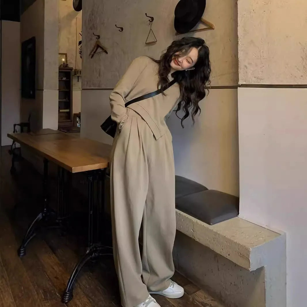 Women's loose brown polyester sports suit with top and trousers on a hanger.