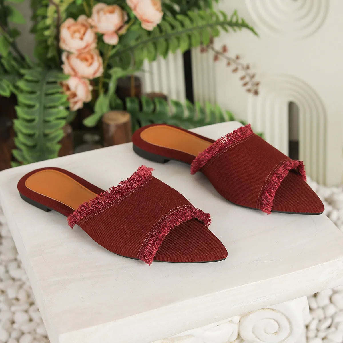 Women's denim flat slippers with tassel trim and leather lining in assorted colours.