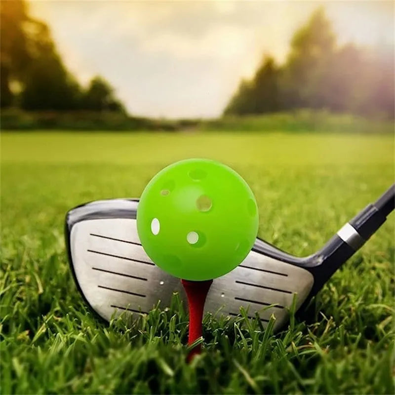 Multi-colour golf practice balls with 26-hole design next to a net storage bag