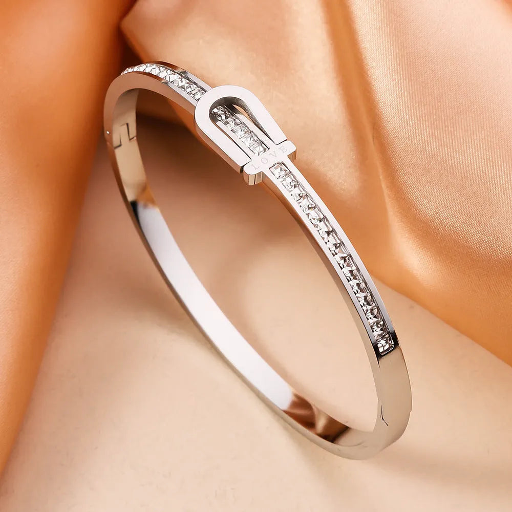 Gold plated titanium steel bangle bracelet with gang drill style, available in gold and steel colours.