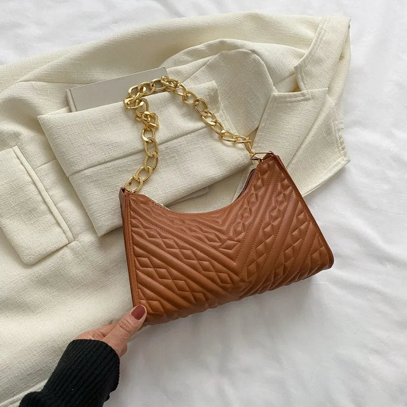 Brown pleated PU baguette shoulder bag with a top handle and long chain strap on a white background.