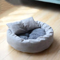 Grey round plush pet bed with raised rim and removable pillow for small dogs and cats.