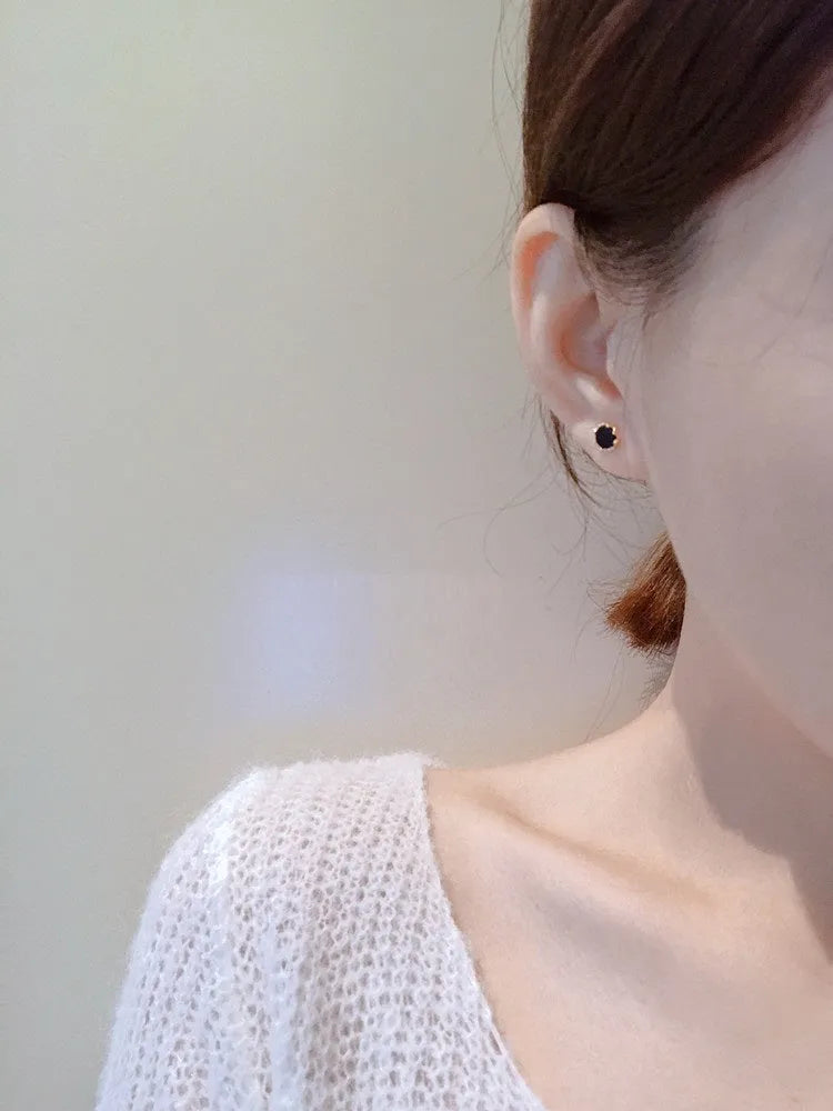 Black round mini ear studs with inlaid zircon, silver plated alloy, 10mm diameter, on a plain background