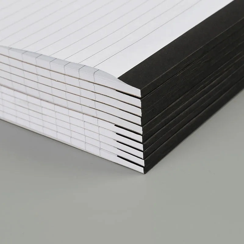 A4 size tearable grid notebook with paper cover, open to show ivory white pages.