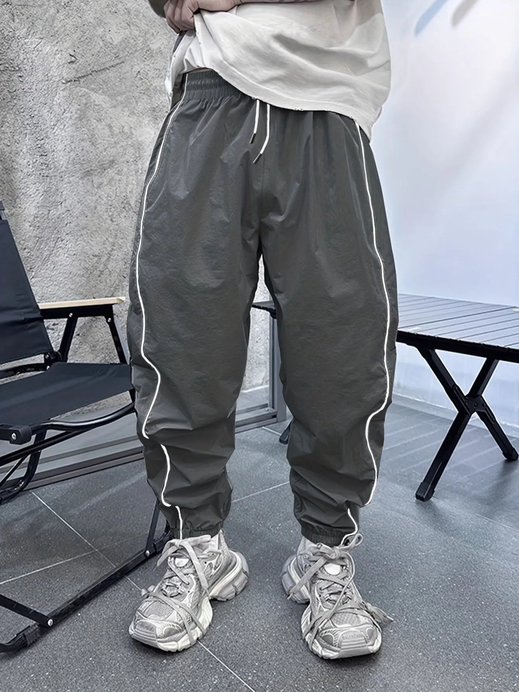 Man wearing loose grey cropped bamboo fibre sports pants in a casual setting.