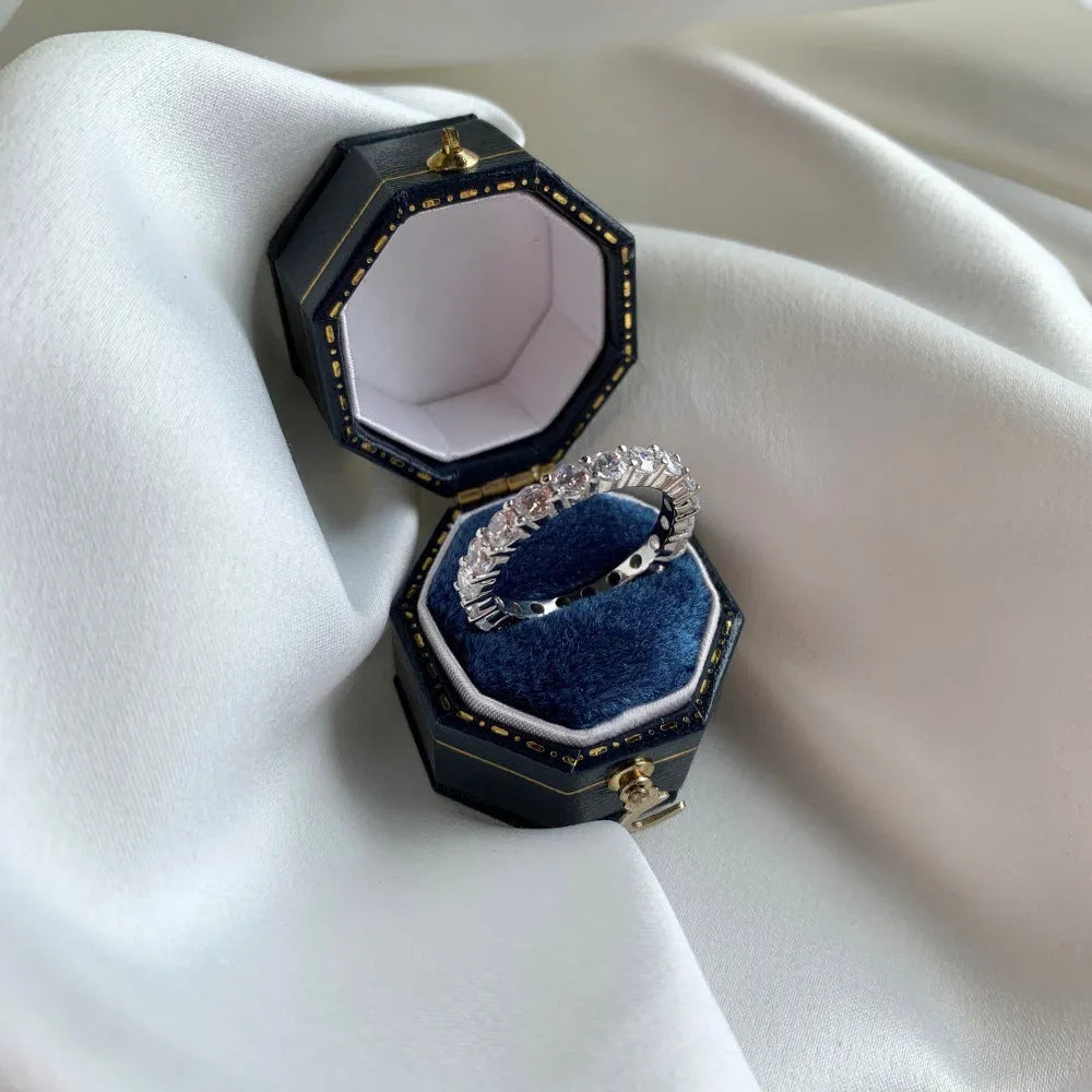 S925 sterling silver ring with geometric round design and white diamond-like stone on light background