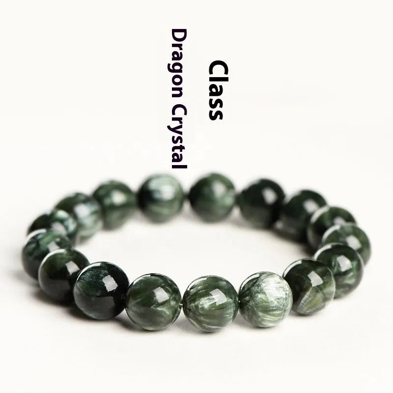Close-up of a green dragon crystal bead bracelet with round geometry beads and a Ruyi charm.