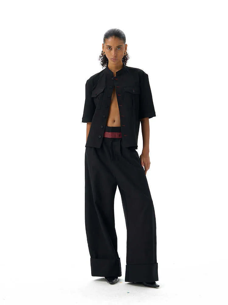Handmade black loose fit half sleeve shirt with a shirt collar on a hanger.
