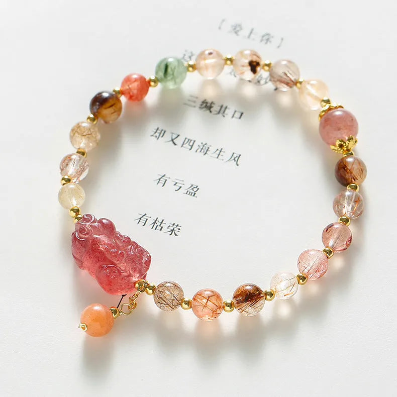 Natural strawberry quartz and copper bracelet with pearl accents on a wrist.