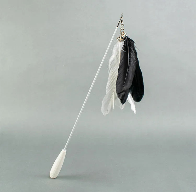 White telescopic fishing rod cat toy extended, with goose feather attachments and a small bell, on a neutral background.