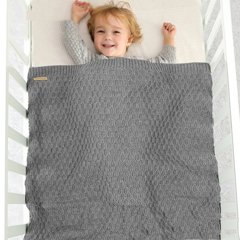 Solid colour infant hug blanket with three-dimensional lines, shown in one of five colour options.