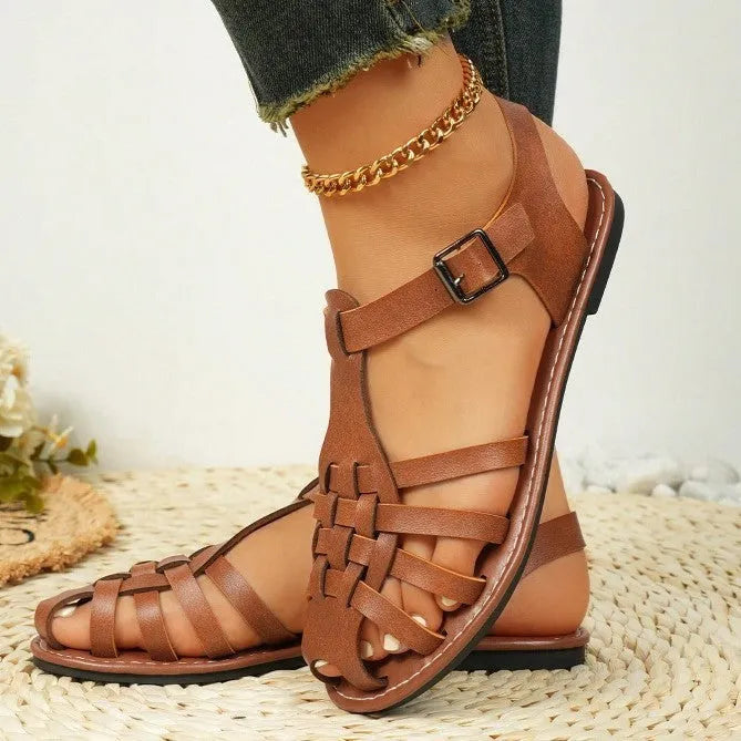 Dark brown women's Roman sandals with woven PU upper and buckle closure on a rubber sole.
